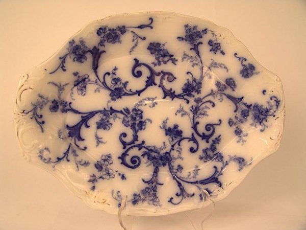 RIDGWAYS FLOW BLUE PLATTER IN GAINSBOROUGH PATTERN: Ridgways "Gainsborough" pattern flow blue platter measures 14 1/2" long by 10 1/2" wide. It's marked "Ridgways England Royal Semi-Porcelain Gainsborough". Also has an impressed number 1 over 99. Has a