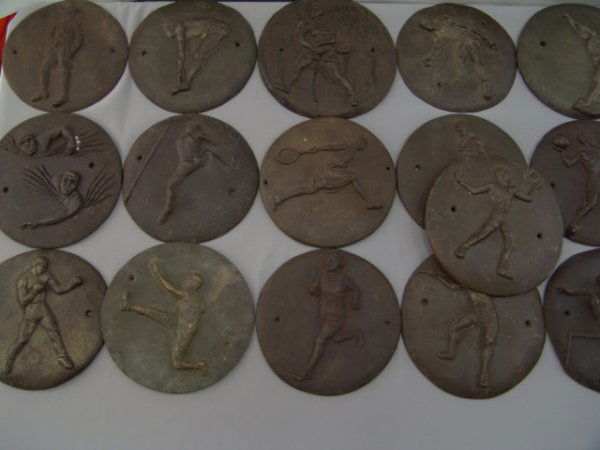 COLLECTION OF 22 CAST PLAQUES: SPORTING & OLYMPIC: These 22 early Olympic Games Plaques show different events from football (showing old dog ear helmet), to diving, boxing to tennis (both male & female), high jump, running, golf, javelin, and more. Ea