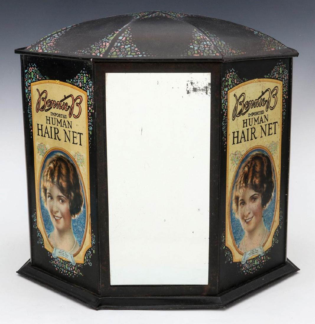 RARE 1930s 'BONNIE B' HAIR NET ADVERTISING DISPLAY: The six-sided tin advertising display with Art Deco lithography graphics and designs, the front panel is set with a mirror for the public to try on the 'Human Hair Net', two panels either side include
