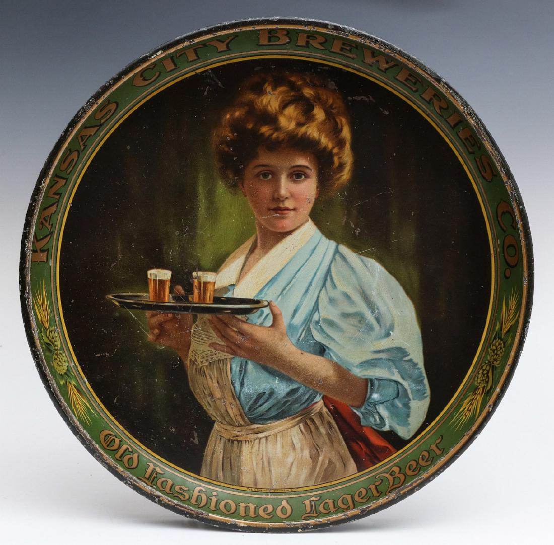 PRE-PROHIBITION TRAY FOR KANSAS CITY BREWERIES CO: A rare circa 1915 lithographed tin advertising tray pictures an Edwardian era maiden in pigeon chested dress and holding a tray with beer in glasses, the rim is lettered KANSAS CITY BREWERIES CO and O