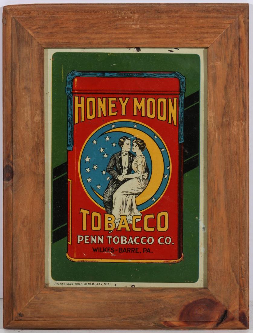 A HONEY MOON TOBACCO TIN LITHO ADVTG SIGN C 1915: The lithographed tin advertising sign embossed HONEY MOON TOBACCO with graphics of a young couple seated on the crescent moon surrounded by stars; signed John Igelstroem Co., Massillon, Ohio in the lo