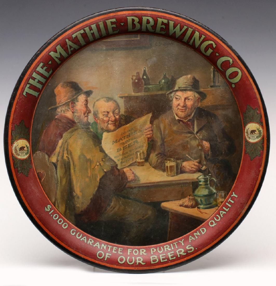 A PRE-PROHIBITION ADVTG TRAY FOR MATHIE BREWING CO: The circular lithographed tin tray picture fellows at a table, one reads a newspaper with advertising DRINK MATHIE BEER. the rim advertises the brewery and pictures a bear similar to California's stat