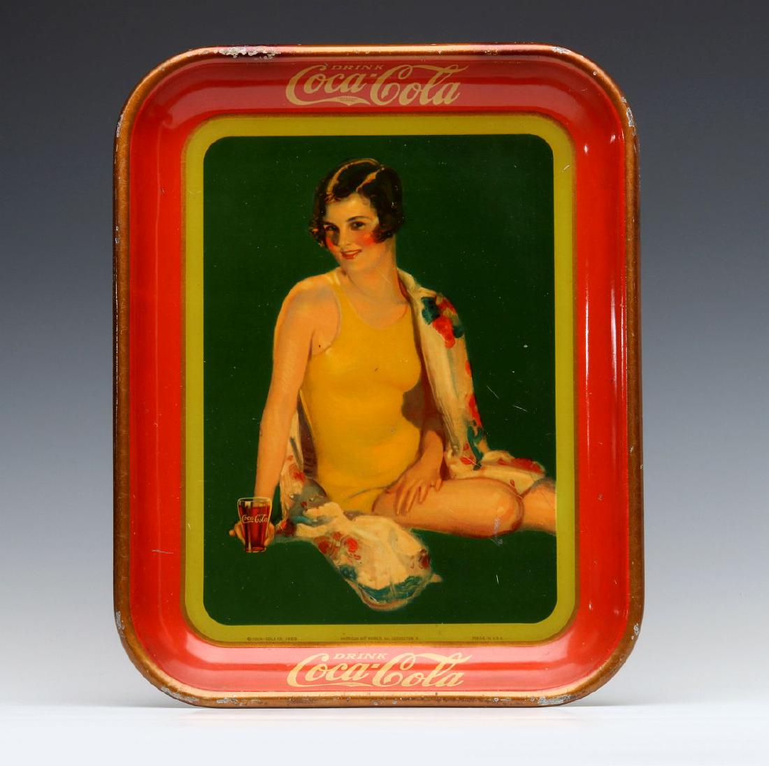 A 1929 COCA-COLA SERVING TRAY W/ SWIMSUIT FLAPPER: The polychrome tin litho serving tray illustrated with a flapper-like woman with bobbed hair wearing a yellow swim suit, fountain drink version, signed American Art Works Coshocton, O. and copyright d