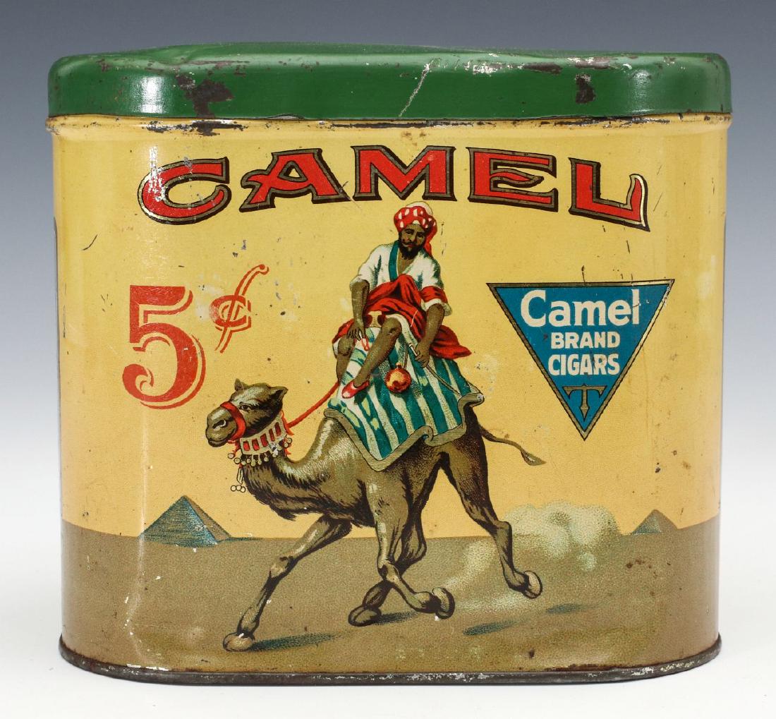 AN ADVERTISING TIN FOR CAMEL BRAND 5 CENT CIGARS: The brightly colored oval container with graphics that include a Bedouin on trotting camel, pyramids and desert, The Very Mild 5c Cigar. Measures 5.5 x 6 x 4 inches. We happily provide seamless in-hou