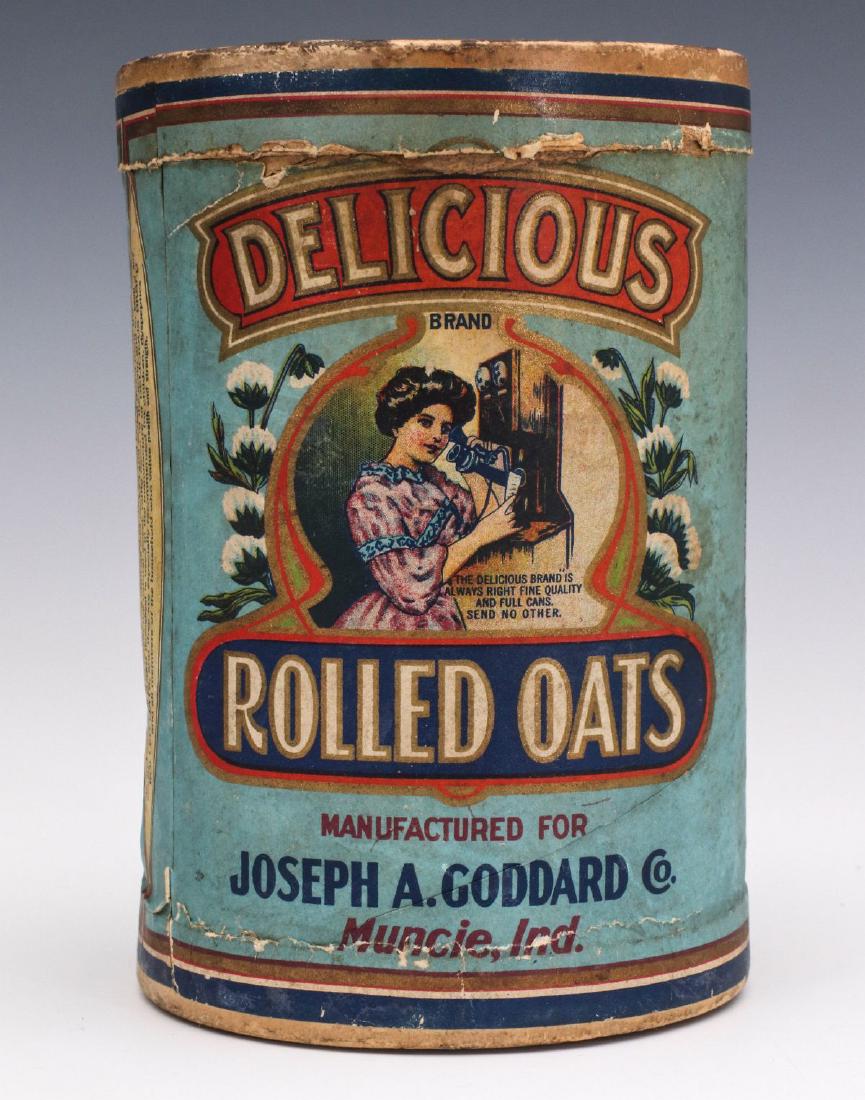 A DELICIOUS BRAND ROLLED OATS CONTAINER CIRCA 1910: The 14 oz. size centered by the image of a woman in Edwardian dress ordering Delicious Brand Oats by phone, an oak double box wall phone circa 1910, and lettered 'Manufactured for Joseph A. Goddard Co