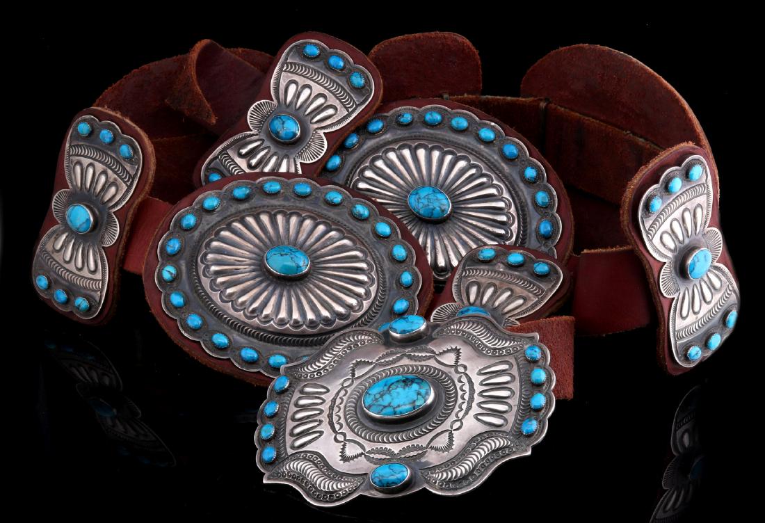 AN IMPRESSIVE KIRK SMITH NAVAJO CONCHO BELT: A large traditional style sterling silver concho belt by Kirk Smith bearing his earlier hallmark. There are four scalloped conchos and five butterflies with deep repousse work and hand stamping backed