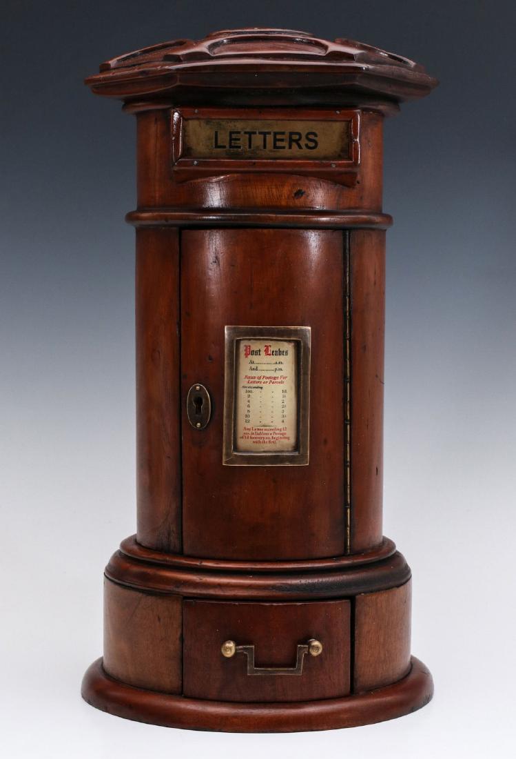 A 19TH C. ENGLISH PILLAR FORM MAHOGANY LETTER BOX: The six-sided cap on cylindrical body with hinged brass door labeled LETTERS in black enamel, rounded front door with lock and piano hinge, circular outset base with drawer. Measures 16 x 8.5 inches. 