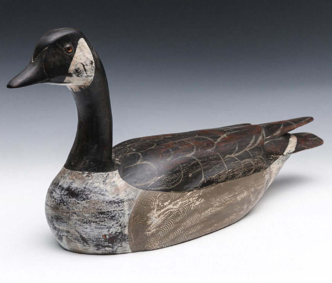 A CANADIAN GOOSE DECOY SIGNED CHARLES MOORE: Carved wings, painted detail, signed Chas. Moore on the underside and dated '87. Measures 9 x 18.5 x 5.5 inches. We happily provide seamless in-house packing and shipping services on nearly everything