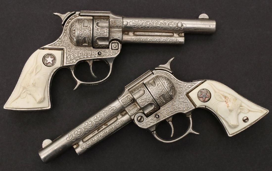 A PAIR OF HUBLEY TEXAN JR. CAP PISTOLS: Matching pair of circa 1940 Texan Jr. cap guns with white embossed white steer head grips. Measure 4.25 x 8.25 inches. We happily provide seamless in-house packing and shipping services on nearly ever