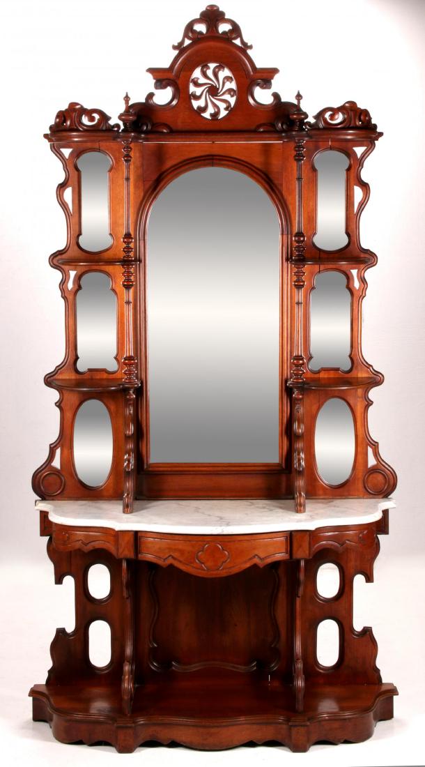 A FINE 19TH CENT AMERICAN ROCOCO REVIVAL ETAGERE: A fine mirrored etagere; the arched top crest centered by an exuberant pierce-carved pinwheel above the central arched mirror flanked by shaped mirrors and shelves supported by delicate turnings, demi