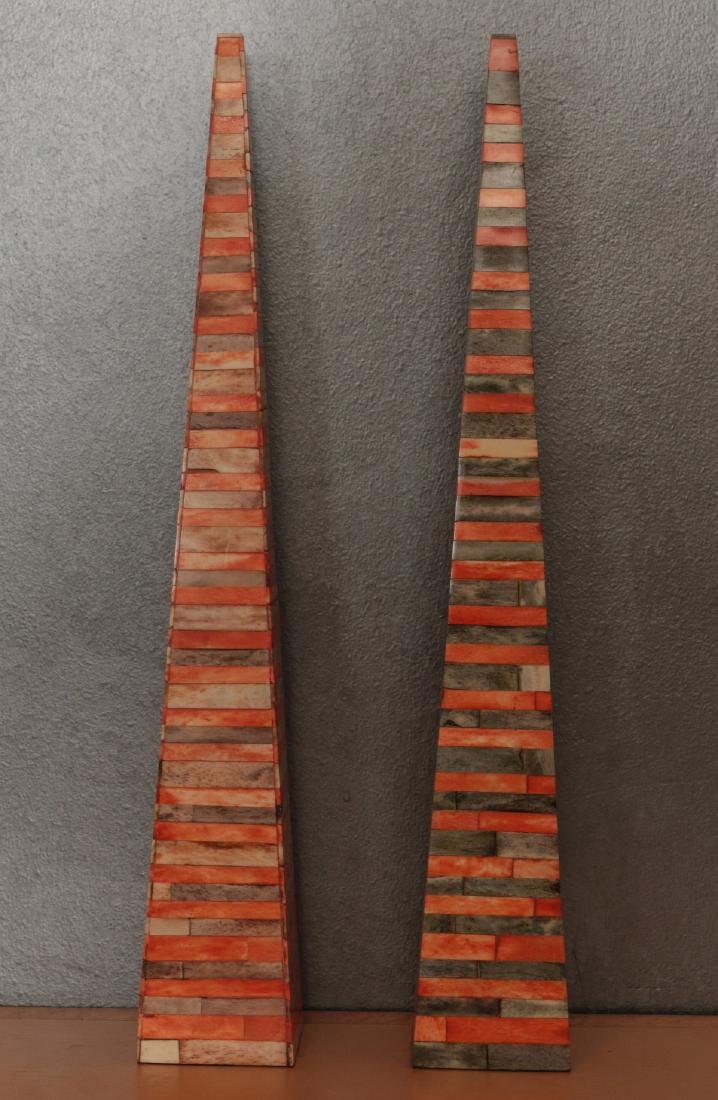 A PAIR CONTEMPORARY 26-INCH VENEERED OBELISKS: A large pair of obelisks covered in horizontally arranged red and gray stained bone tiles. Each measures 26 x 4 x 4 inches. We happily provide seamless in-house packing and shipping services on nearly