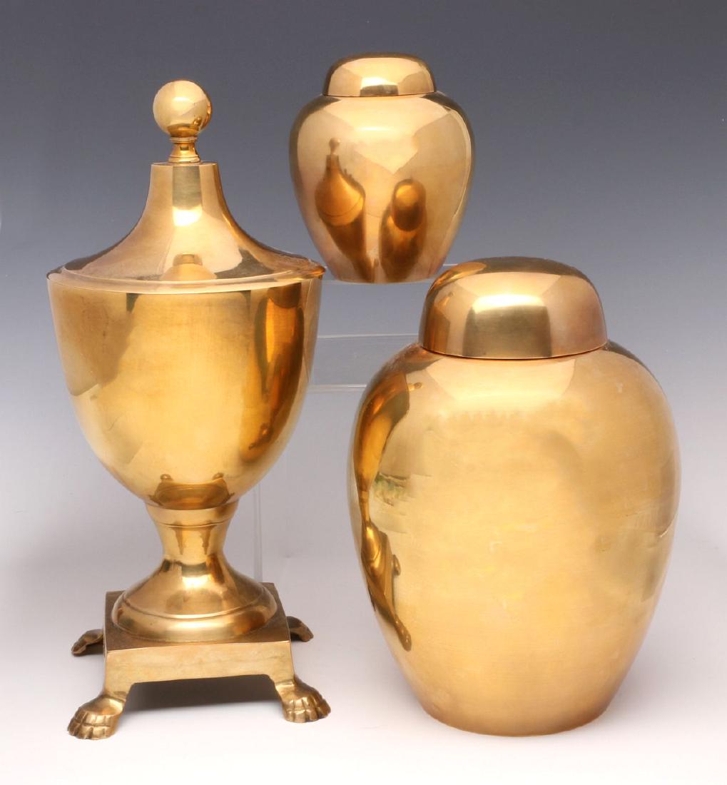 A COLLECTION OF DECORATIVE BRASS OBJECTS: A covered urn and two ginger jars. Measurements range from 4.75 to 13.5 inches. We happily provide seamless in-house packing and shipping services on nearly everything we sell.