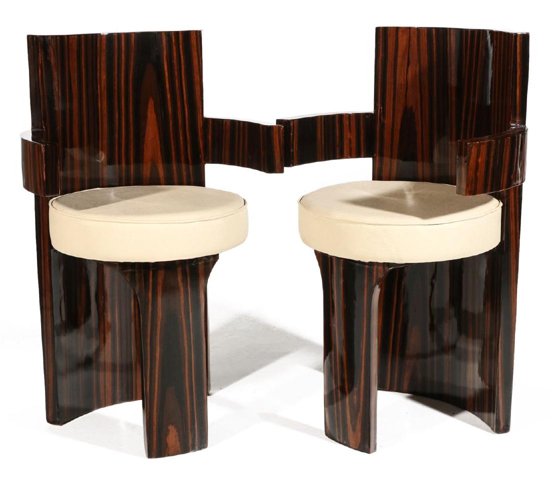 A PAIR CONTEMPORARY ZEBRA WOOD BARREL CHAIRS: The high style pair of semi-circular form, highly figured zebra wood type veneers. upholstered cushions with grained cowhide type covering. Measures 35 x 18 inches. We happily provide seamless in-hous