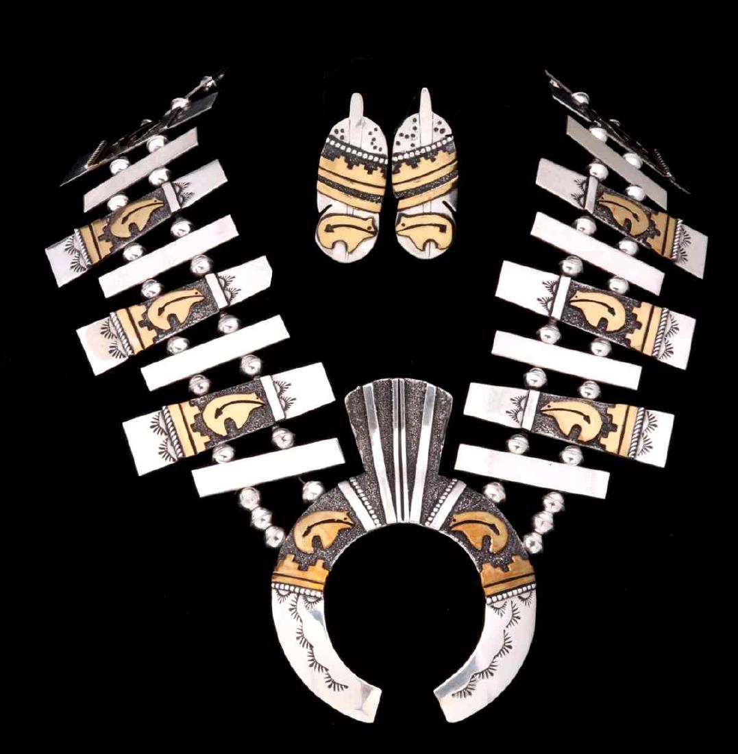 A TOMMY SINGER NAJA NECKLACE AND EARRING SET: The Tommy Singer (1940-2014) contemporary design squash blossom inspired set with earrings featuring overlaid gold-filled heartline bear motif on links, naja and earrings. In native beliefs, the bear 
