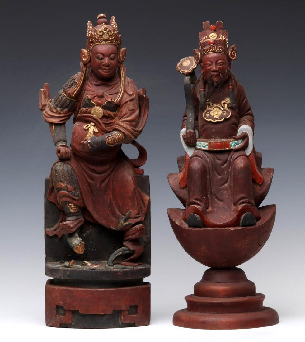A PAIR EARLY 20TH C. CHINESE CARVED DAOIST FIGURES: The pair of carved, iron-red painted and gilded wood figures in Ming dynasty style, Daoist deities wearing rich costume and head pieces, each seated upon differing integral bases. Measures 17.75 inche