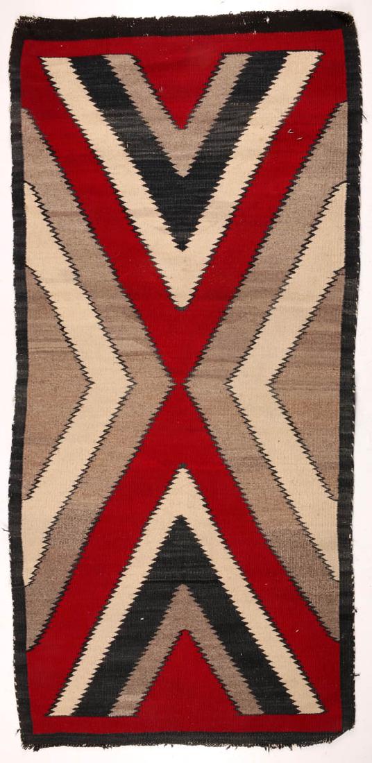 A NAVAJO GANADO WOOL WEAVING: The overall pattern of serrated half diamonds and quarter diamonds in red, black, ivory and natural wools. Measures 59 x 28.5 inches. We happily provide seamless in-house packing and shipping services