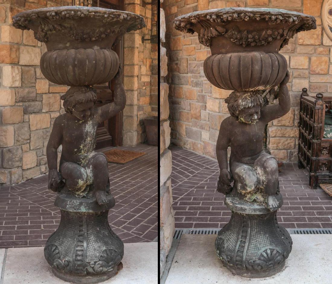 A PAIR MODERN 46-INCH BRONZE FIGURAL GARDEN URNS: The contemporary pair with campagna urn form bowl with swags and melon ribs atop a crouching child figure raised on pedestal plinth, 20th century one-piece bronze planter. Measures 46 x 22.5 inches. P