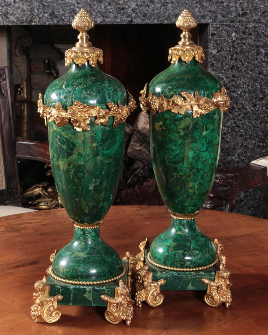 FINE 20TH C. MALACHITE AND ORMOLU VASE PAIR: The pair with malachite veneer and gold plated bronze mounts, possibly Baldi, Italy. Each measures 23.5 x 7 x 7 inches. Provenance: Spirit of Avalon Mansion and Gardens, Lake Quivira, Kansas For this