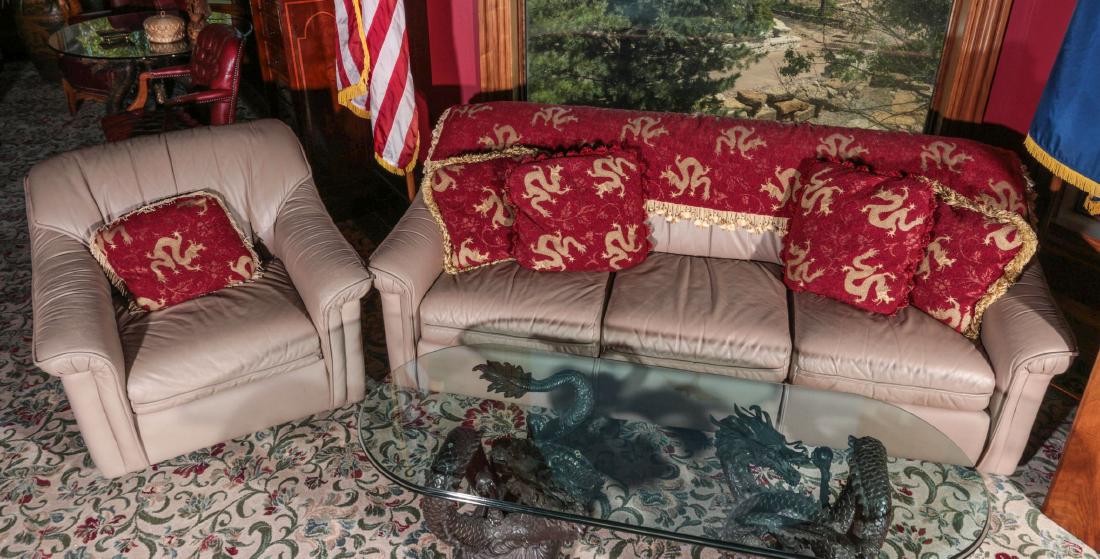 LEATHER SOFA AND ARM CHAIR WITH DRAGON MOTIF THROW: Leathercraft sofa and matching arm chair, accented with woven throw and matching pillows with Asian dragon motif embroidery. Couch measures 32 x 84 x 38 and the chair is 31.5 x 36 x 38 inches. Provena