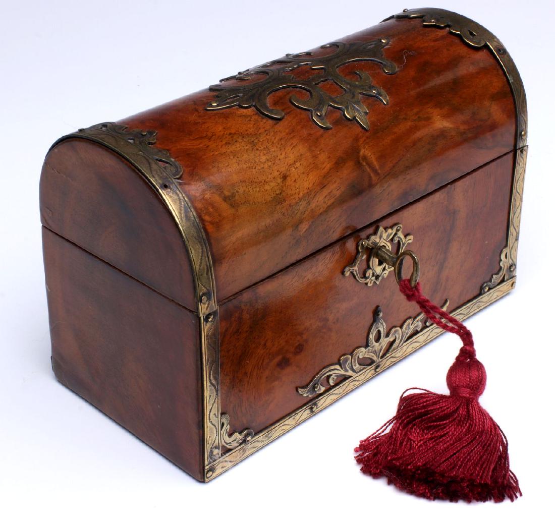 A HANDSOME ANTIQUE BRASS BOUND BRITISH LETTER BOX: The solid mahogany domed form with hand-engraved brass ornamentation with aged patina applied to top, sides and key hole; highly figured mahogany woods in warm mellow patina, divided maple interior, a