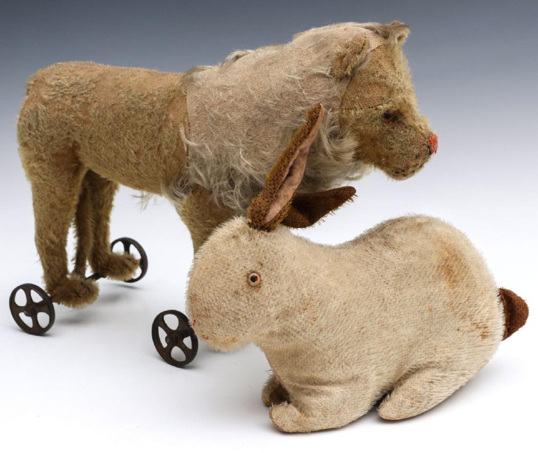 AN EARLY STEIFF MOHAIR LION ON WHEELS: The excelsior-filled body with worn gold mohair overlaid with blonde mane, vertically stitched nose, iron wheels, unsigned. Plus and early blonde mohair rabbit with, red nose, golden ears and tail, un