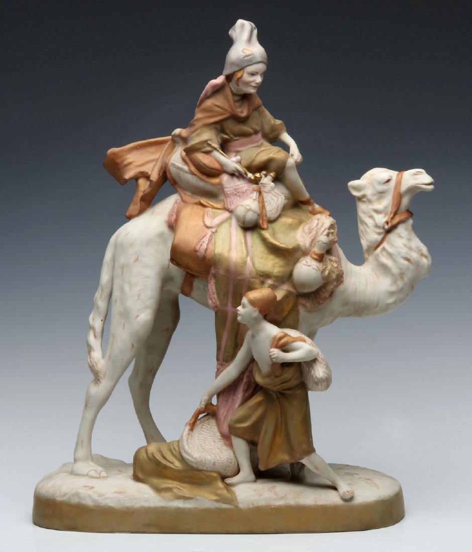 A ROYAL DUX PORCELAIN FIGURE GROUP: The elaborate figure group with a camel and rider attended by a foot servant, signed by pink porcelain Royal Dux signature tag applied under the base. Measures 18.75 x 14 x 6.75 inches. We happily pro