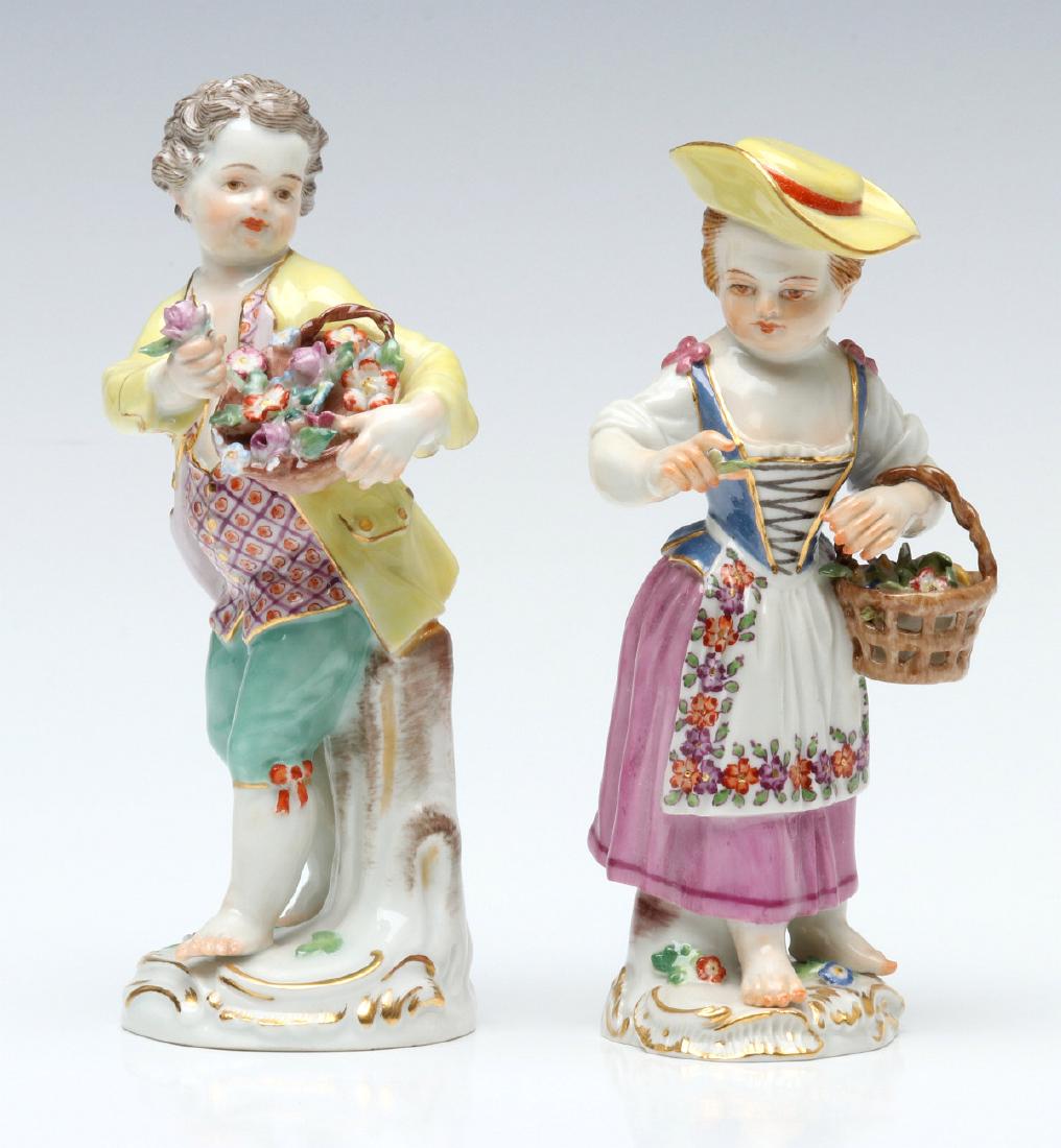 TWO MEISSEN PORCELAIN CABINET FIGURES: Similar girl and boy figures with flower baskets on rococo base, brightly colored 18th century garb, blue crossed swords mark under the glaze, circa late 19th century. Measure 5 x 2.25 and 5.25 x 2.5