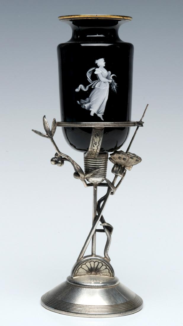 AN VICTORIAN AESTHETIC MOVEMENT GLASS & SILVER WHAT-NOT: The silver-plated stand of unmistakable Aesthetic Movement influence mounted with a Mary Gregory type enameled black glass bud vase insert attributed to Bohemian art glass make, circa 1880. Measures 9
