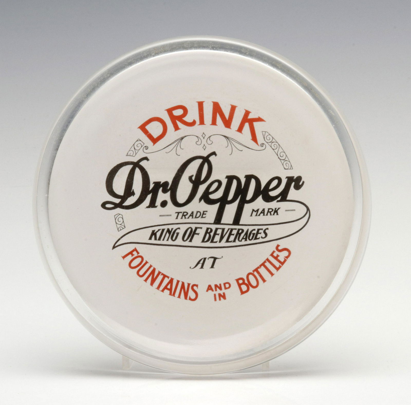 A VERY RARE PAINTED GLASS DR. PEPPER CHANGE TRAY: The rare early circular glass tray with raised edge, white ground fired-on enamel with lettering in red and black advertising DRINK Dr. Pepper KING OF BEVERAGES AT FOUNTAINS AND IN BOTTLES, the graphi