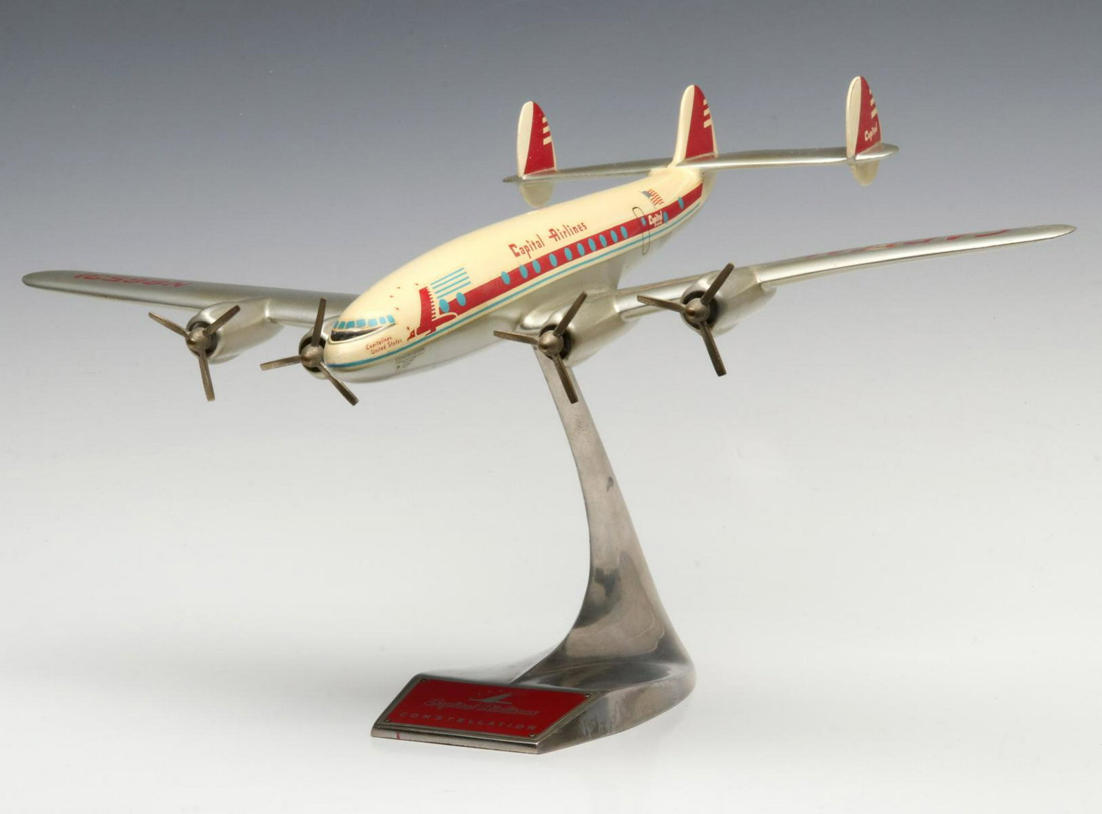 A SCARCE CAPITAL AIRLINES CONSTELLATION DESK TOP MODEL: The scarce and desirable model on aluminum stand, a prop-driven Constellation passenger plane model complete with red and white graphics and windows depicted in blue, Capitol Airlines was in business 