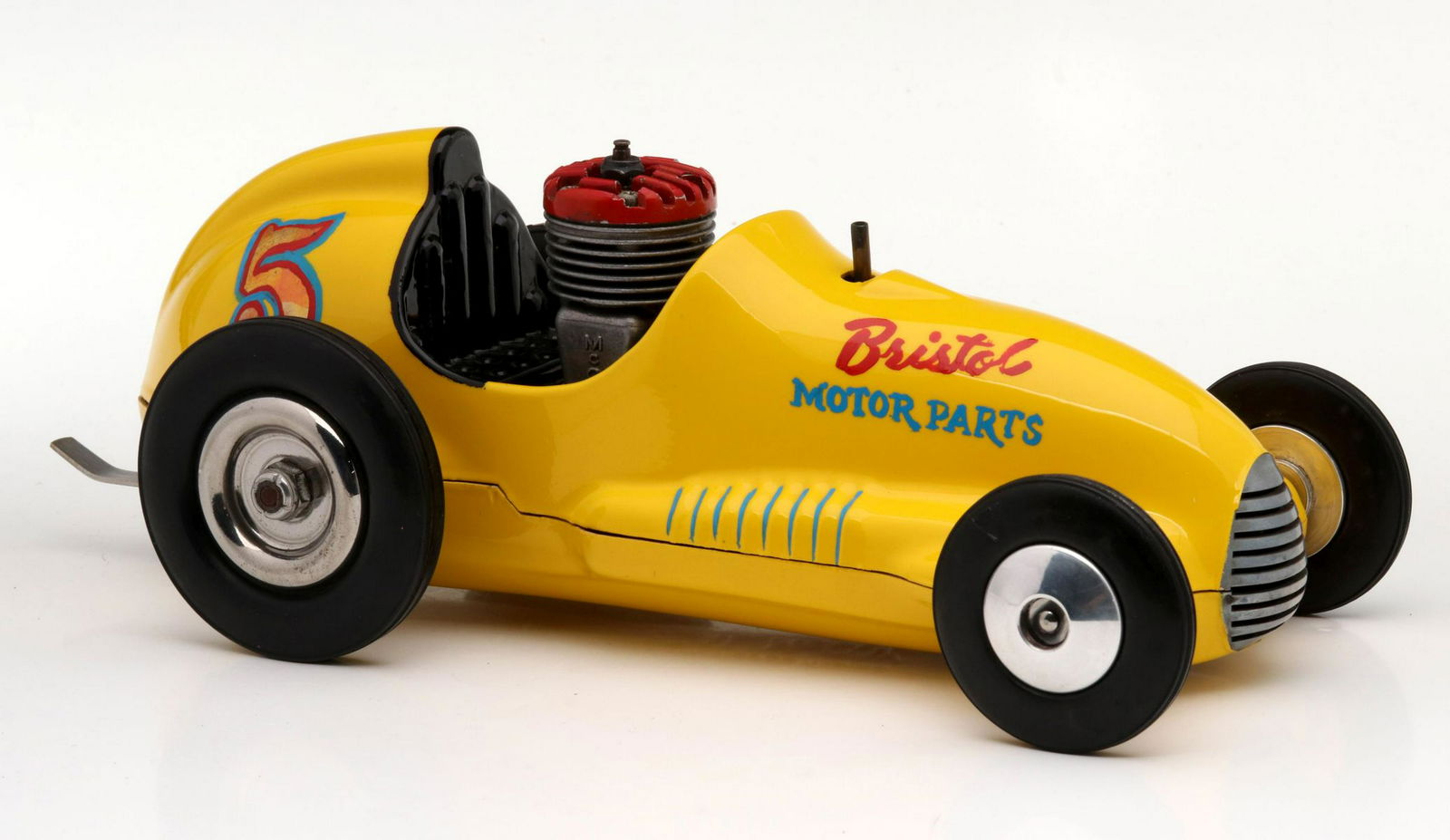 A GOOD ORIGINAL MCCOY TETHER CAR WITH REDHEAD ENGINE: A very nice example with MCCOY redhead engine., bright yellow paint, hand painted advertising, embossed FOR THE BEST IN MODEL RACING IT'S THE REAL McCOY. Measures 3.75 x 10.5 inches. Provenance: The 4
