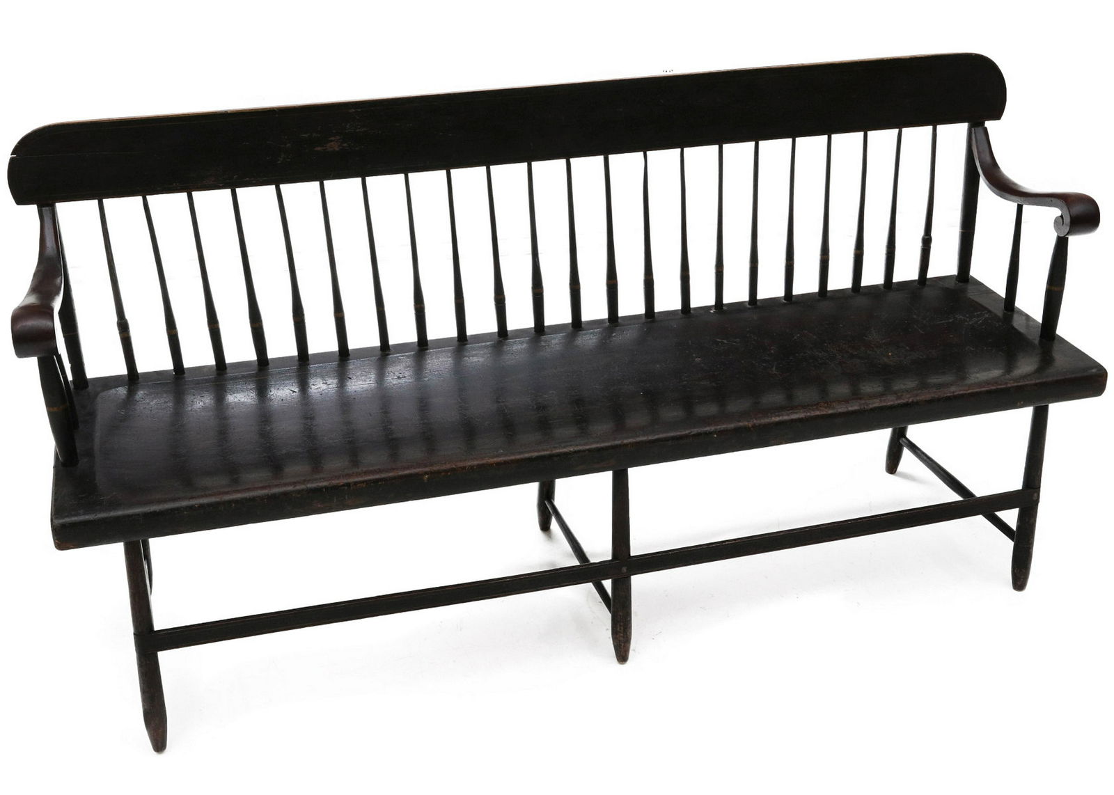A 19TH CENTURY AMERICAN WINDSOR STYLE SETTLE BENCH: The long settle with scrolled arms at each end of the spindled back with flat tablet crest, one-board plank seat raised on tapering turned legs joined by thin slat stretchers, original black stain thr