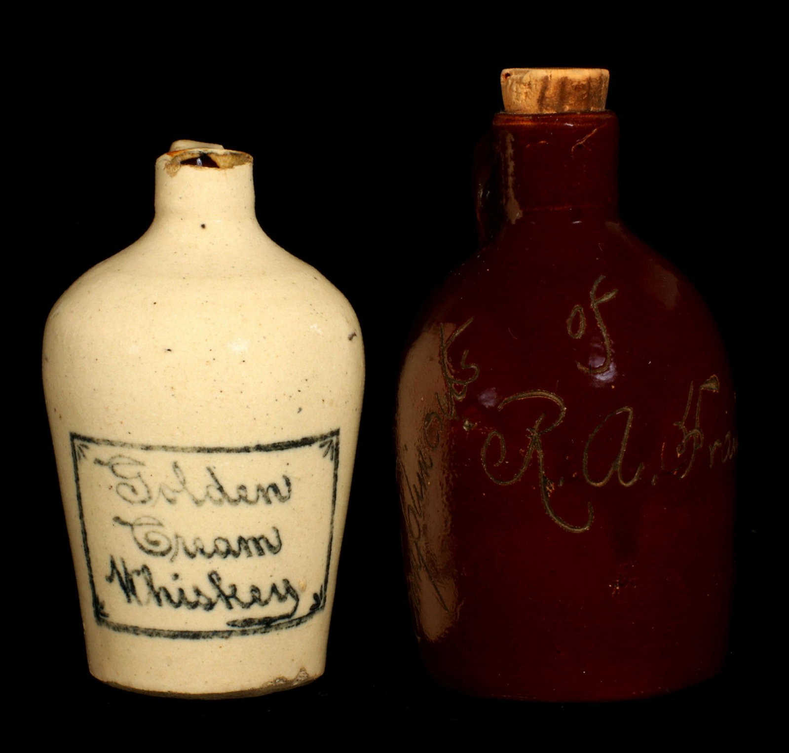 TWO CIRCA 1900 STONEWARE WHISKEY ADVERTISING MINI JUGS: A Bristol glaze jug with blue stenciled box framing the advertising for Golden Cream Whiskey; plus an Albany slip glaze scratch jug lettered Compliments of R. B. Francis. Measures 3.25 x 1.5 and 4 x 2