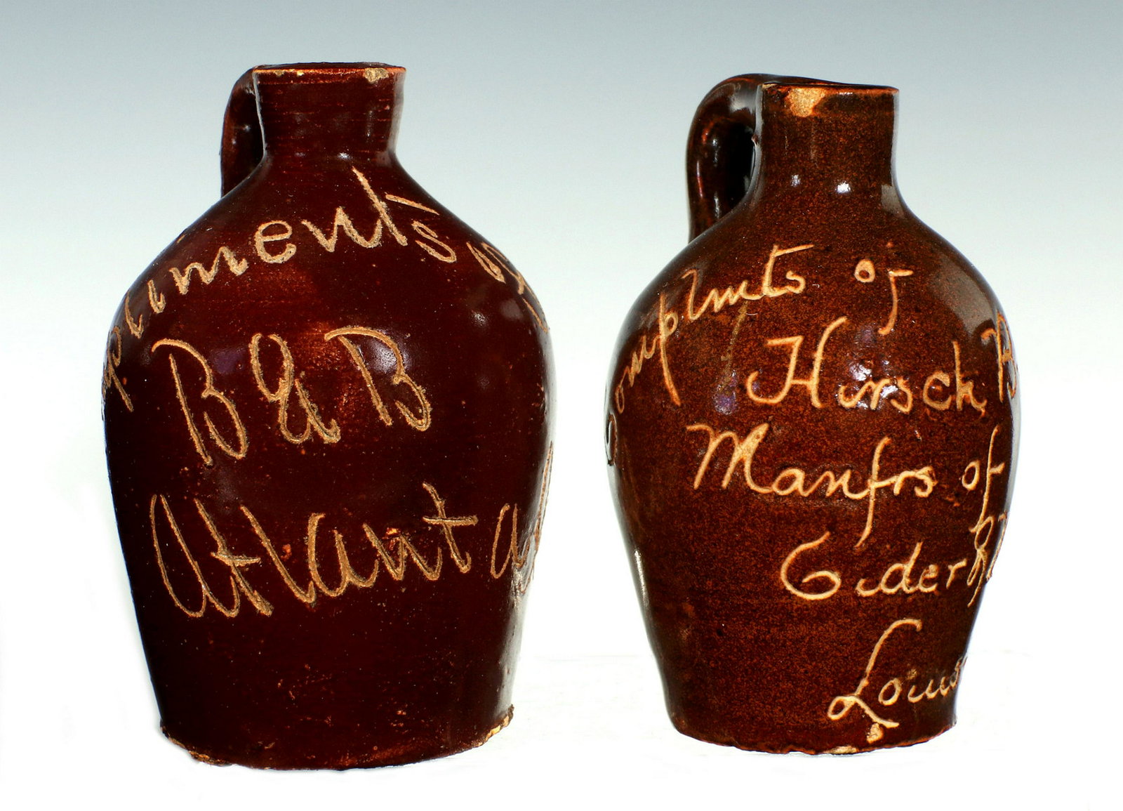 TWO CIRCA 1900 SCRATCH STONEWARE ADVERTISING MINI JUGS: One is etched ' Compliments of B & B Atlanta GA' and the other ' Compliments of Hirsch Bros & Co Manfrs of Ciders & Vinegars Louisville Ky. Measures 3 x 1.5 and 3 x 1.75 inches. Provenance: The 45-yea