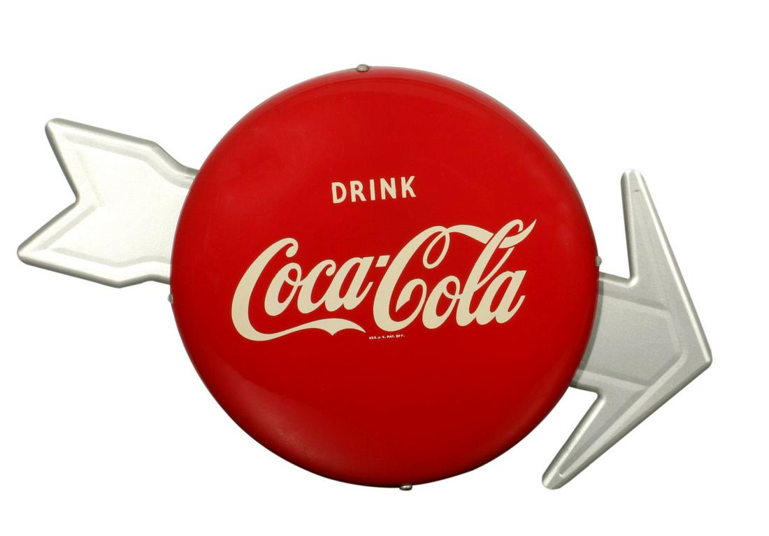 A 1950s COCA-COLA BUTTON SIGN WITH ARROW: The red button with white lettering and silver arrow, The red button with white lettering and silver arrow, marked A&M Sign Co, Lynchburg, VA. 4-49 lower edge. Button sign measures 12 inches, the arro