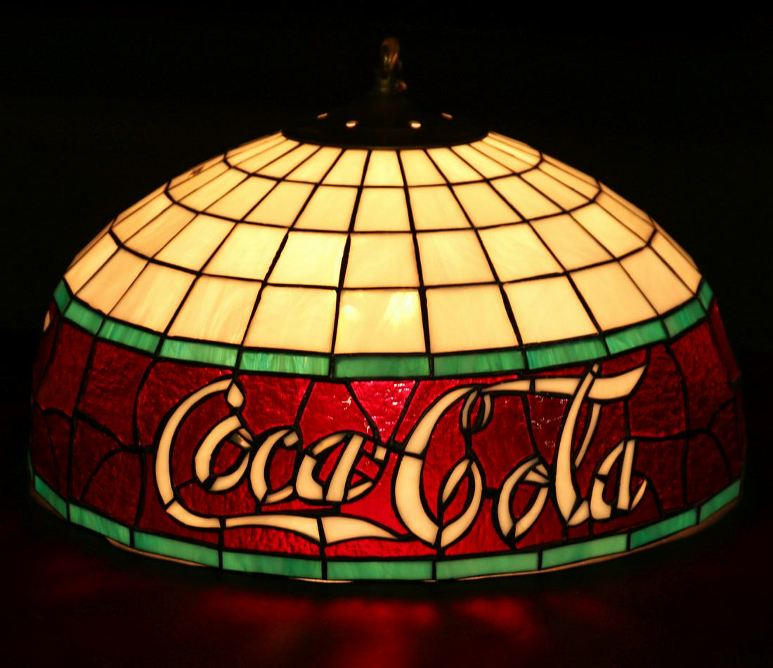 A LATE 20TH CENTURY COCA-COLA ADVERTISING LEADED LIGHT: The leaded fixture with white glass lettering leaded within red textured glass with green trim. Shade measures 10 x 18 inches. Provenance: The 45-year collection of Michael and Donna Hayes, West Plain