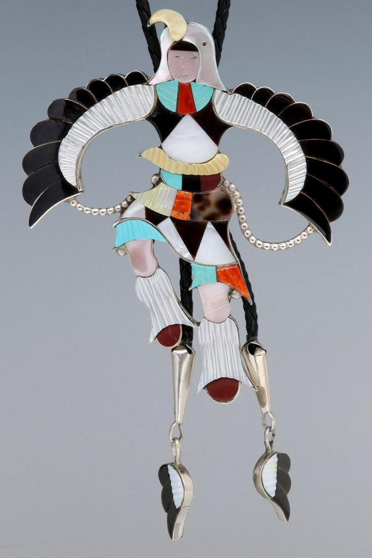 AN OUTSTANDING EAGLE DANCER INLAID BOLO SIGNED J BELUKA: The large and dramatic multi-stone inlaid Eagle Dancer bolo tie with hand cut and carved stones of turquoise, tortoise shell, pipe stone, coral, mother of pearl, jet, gold lipped muscle and pink muscl
