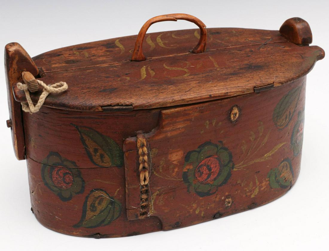 A SCANDINAVIAN BRIDE'S BOX WITH RED STAIN AND FLORALS: The early 19th century bentwood bride's box with carved wood handle, traditional wood key locking mechanism, red stain with initials and 1840s date in ochre, polychrome floral painted decoration, lap