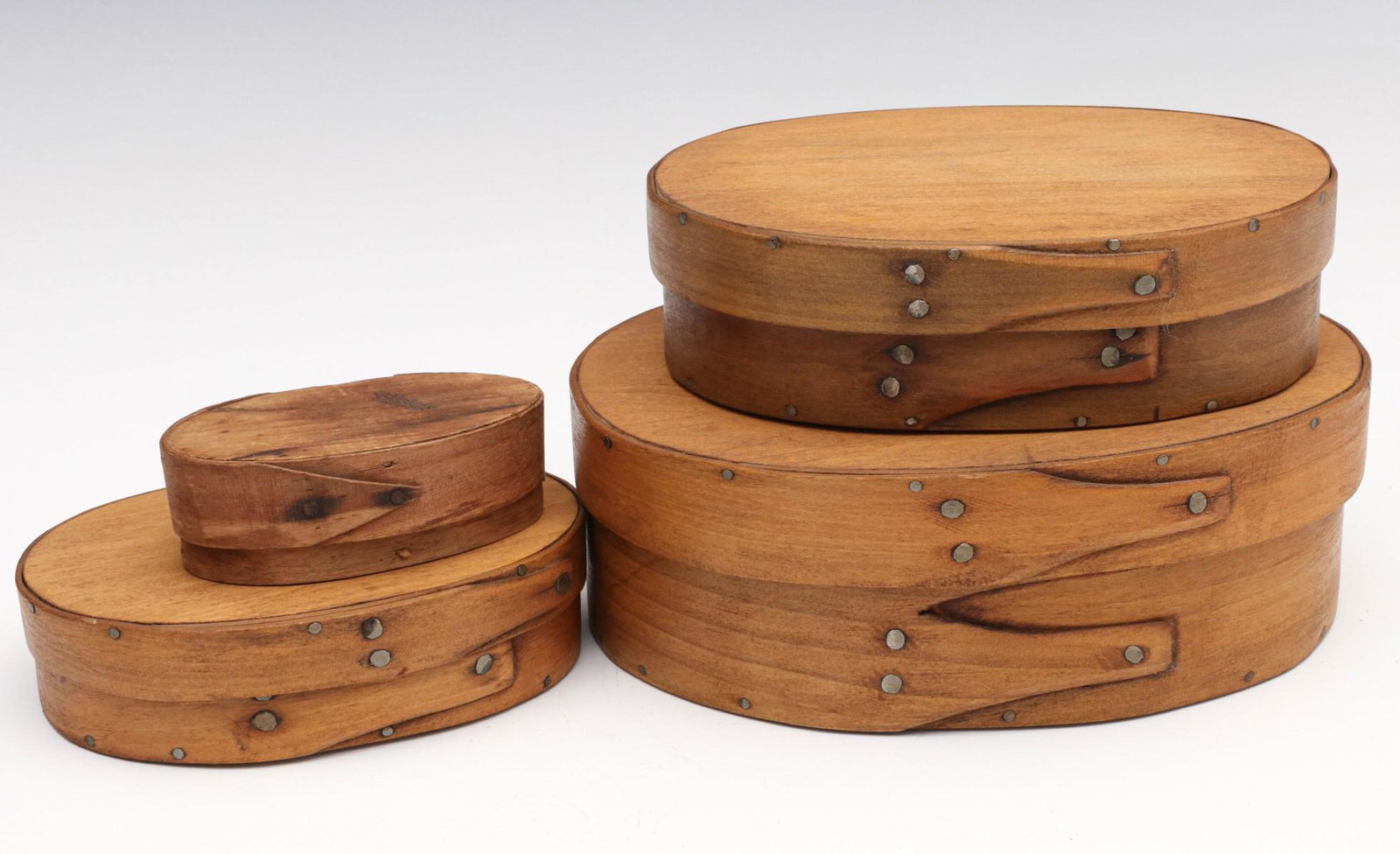 FOUR ANTIQUE BENTWOOD PANTRY BOXES OF GRADUATED SIZES: The majority with matching tacked finger construction, the smaller differs and is constructed with wood pegs. Measures 1.25 x 3.5 x 2 to 2.5 x 7.25 x 5.5 inches. We happily provide seamless in-house p