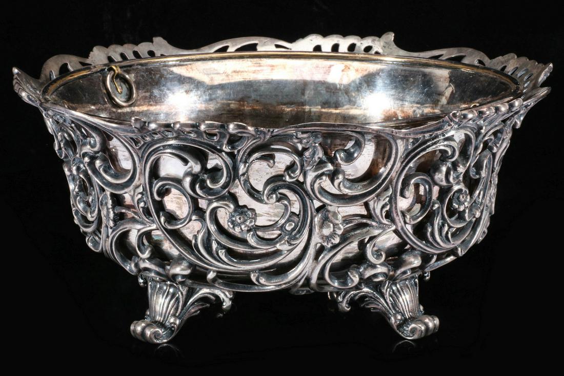 A STERLING ROCOCO CENTERPIECE SIGNED LORING ANDREWS CO: The high quality sterling silver footed centerpiece with silver-plated liner; the intricate openwork design of rococo swirls with foliate and flower blossoms, the whole raised on four ornate scrolled 