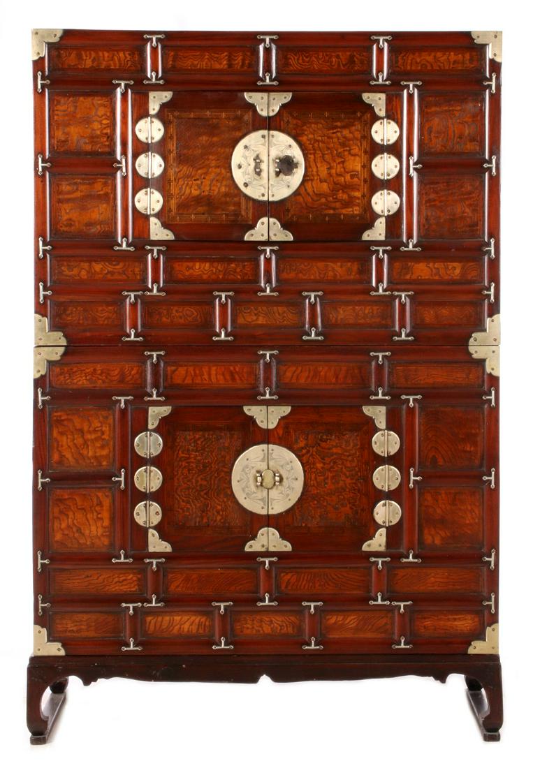 AN OUTSTANDING KOREAN TANSU WITH TIGERED FIGURING: The two-piece cabinet with multiple divided exterior front panels and extensive nickel mounts, two doors center the upper and lower cabinets the whole raised on a bracket foot base with stretchers fro