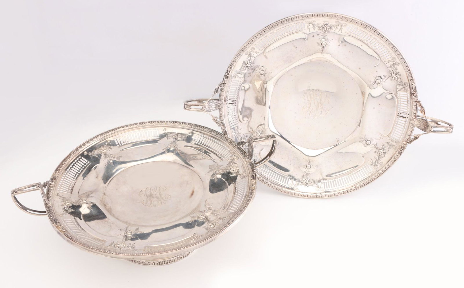 A MATCH PAIR OF STERLING SILVER COMPOTES CIRCA 1920s: The pair with reticulated edge, chased floral sprays, formed interiors with lobes and high strap handles, maker's mark on each for Watson Company. Measure 4.25 x 11.5 each across the handles. Total we
