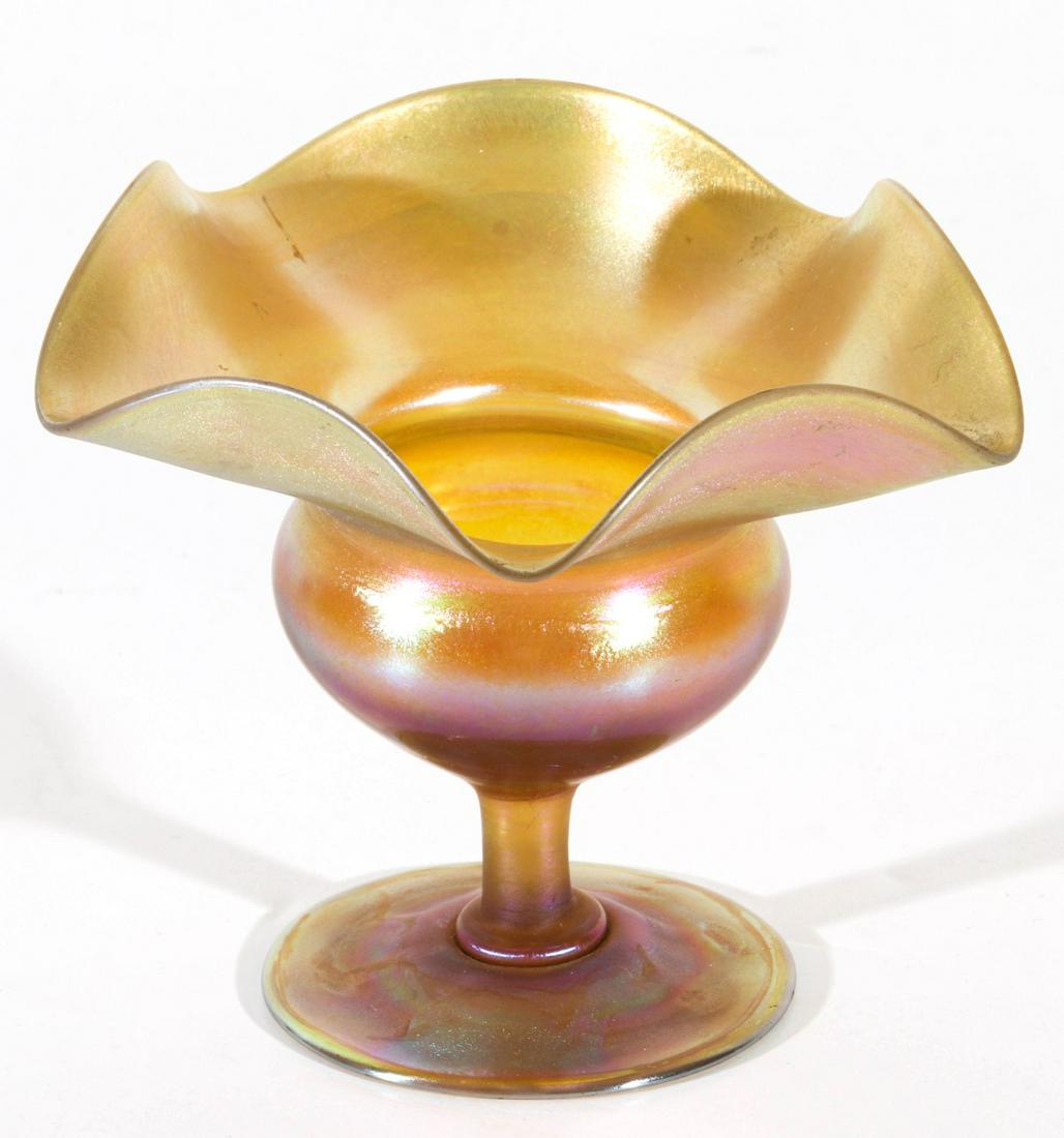 AN ART GLASS VASE WITH LARGE FOLDED RIM SIGNED L.C.T: The stemmed vase with inverted saucer foot, short stem, bulbous vessel with large folded undulating rim, signed L.C.T. and numbered 5911A, The gold Favrile iridescent finish tinged in purple and blue.