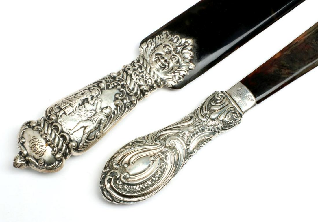 TWO ORNATE 19TH C STERLING AND TORTOISE PAGE TURNERS: The largest with the most ornate handle stamped London, 1883 with visage mask overlaying the blade and embossed rococo handle with courting scene of lovers in 18th century dress. The other example wit