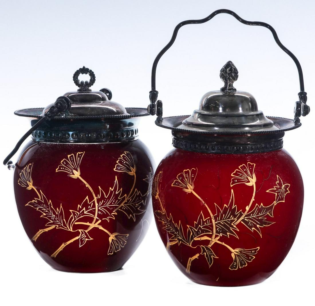 ENAMELED ART GLASS BISCUIT JARS ATTRIBUTED THOMAS WEBB: Cased glass jars in deep ruby, raised gilt enamels, silver-plated mounts, unsigned. Sizes 7.75 and 8 x 5.50 inch diameters. We happily provide seamless in-house packing and shipping services on nearly