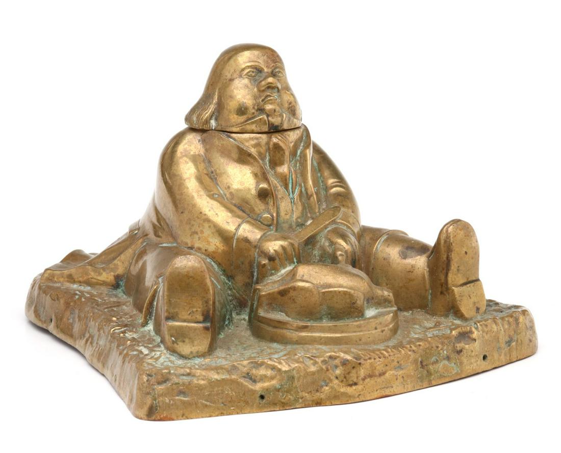 A 19TH C BRASS DANIEL LAMBERT CHARACTER INK WELL: The figural brass ink well characterizing the famously large figure from 18th century lore, Daniel Lambert carving a goose, hinged lid, brass insert, unsigned. Measures 4 x 6.25 x 6.25 inches. We happ