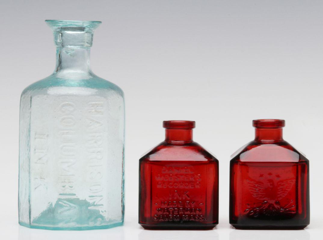 RED AND AQUA 19TH CENTURY ADVERTISING INK BOTTLES: Two red glass ink bottles embossed with eagle branded 'Daniel Webster's Recorder Ink - Made By - Waterman Salem, Mass.' Plus a green glass bottle with kick-up base embossed 'Harrison's Columbian Ink.'