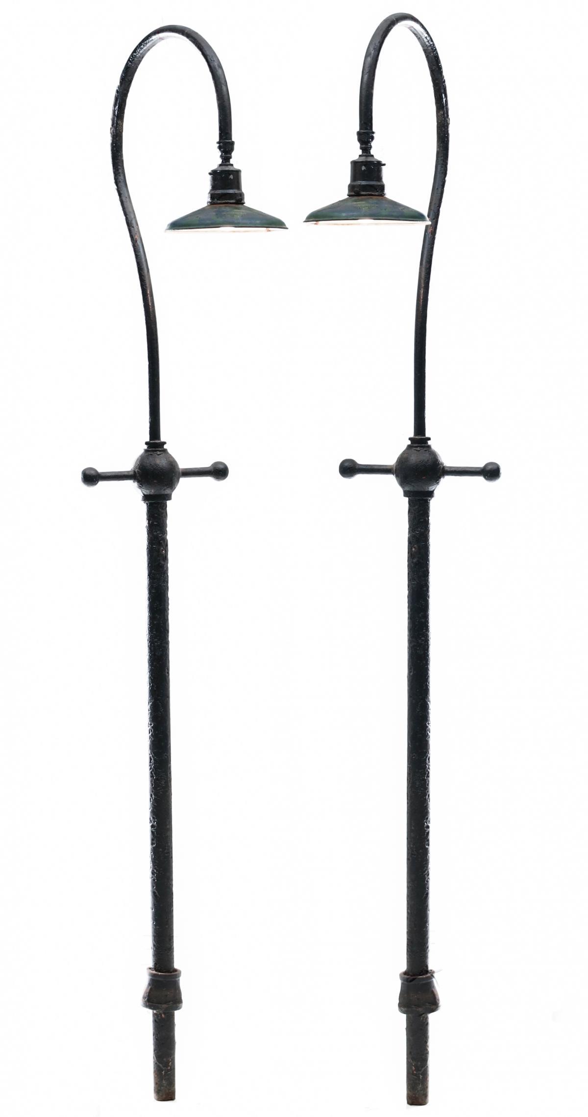 PAIR IRON EXTERIOR LIGHT POSTS FROM B&O SILVER SPRING: The cast iron pair with painted shades from the Silver Spring, Maryland station on the Baltimore and Ohio Railroad. Measures 106.5 x 17.5 x 28 inches. Provenance: The Collection of Ed McHugh, Massillo