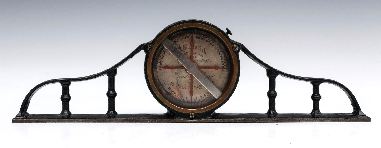 A W.B. MELICK CLINOMETER INCLONIMETER GRADING SCALE: The rare machinist's tool used for striking angles, cast iron frame with spindle gallery and central circular opening housing a mechanism with silvered hand-engraved dial with two scales, maker's name