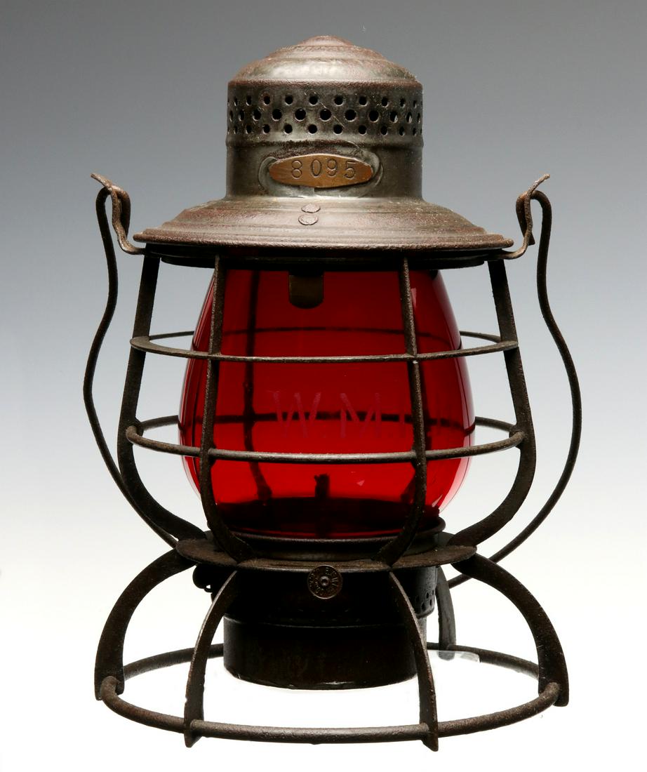 A WESTERN MARYLAND RAILWAY TALL RED GLOBE LANTERN: The wire frame embossed W. M. RY. on the shoulder and the red extended-lip globe acid etched W. M. R. R., applied copper tag stamped with numerals 8196 soldered just above the shoulder, E Miller burne